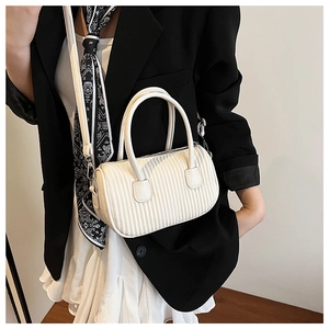 Detail of white cylinder Boston bag featuring vertical pleated texture and silver hardware