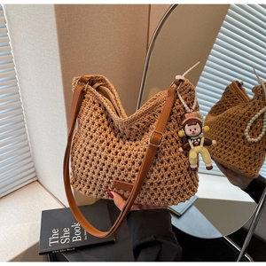 Detail of hand-woven crochet shoulder bag with leather strap and cute character charm
