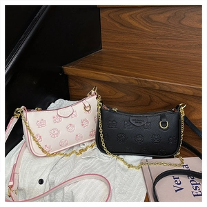 Détail d'un sac à bandoulière imprimé avec chaîne dorée et fermeture éclair