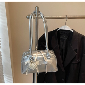 Détail du sac à bandoulière argenté brillant avec perles et breloque en dentelle