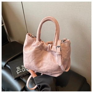 Close-up of pink bucket bag with drawstring detail and lychee texture leather finish