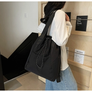 Close-up of black nylon drawstring tote bag with large capacity and durable texture