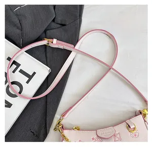Détail du sac bandoulière en cuir rose avec gaufrage de dessin animé et chaîne dorée
