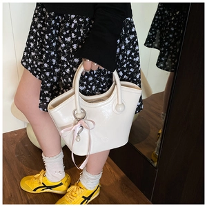 Gros plan du sac seau brillant blanc crème avec un charmant nœud en ruban rose