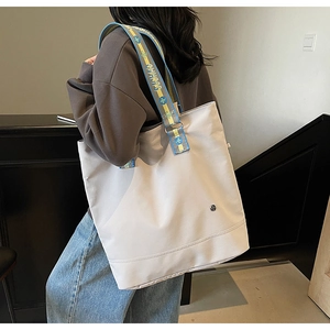 Detail of high-capacity tote bag with stylish wide jacquard lettering shoulder strap
