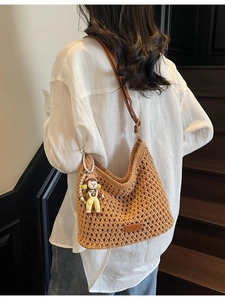 Brown knit crochet shoulder bag with leather straps and a cute doll pendant