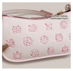 Vue détaillée du sac en cuir rose avec motifs de signes du zodiaque et fermeture dorée