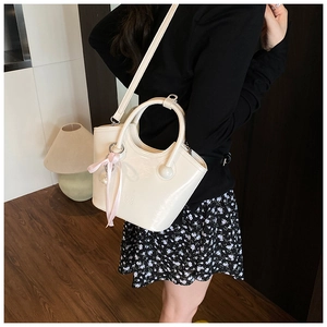 Détail du sac seau crème avec ruban rose et logo CHIO 2ND dans un intérieur douillet