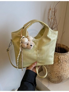 Avocado green crocodile embossed bucket bag with cute plush puppy charm and strap