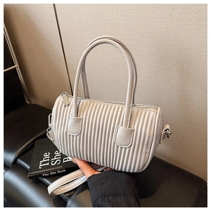 Detailed view of the vertical pleated texture on a retro light grey cylinder bag