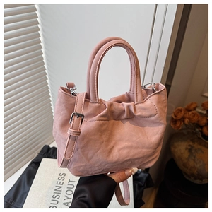 Detailed close-up of pink bucket bag featuring soft pleated texture and silver hardware
