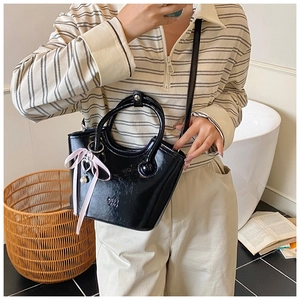 Sac seau noir brillant avec logo BMB, breloque cœur perle et nœud rose élégant