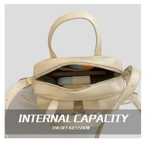 Détail montrant l'intérieur spacieux du sac baguette crème avec les objets essentiels du quotidien