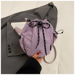 Close-up of light purple nylon bucket bag with drawstring and side mesh pocket detail