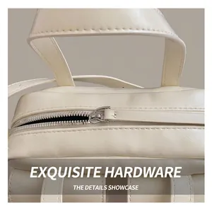 Détail de la fermeture éclair en métal argenté et coutures sur le sac baguette crème