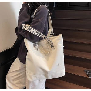 Detail of wide SJCHAO strap and reinforced seams on a large canvas tote bag
