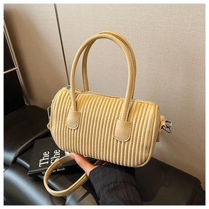 Detail of cream pleated cylindrical bag showing litchi grain leather and silver zipper