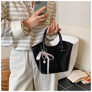 Sac seau trapèze noir verni orné d'un ruban rose et d'un pendentif en forme de cœur perlé