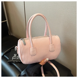 Close-up of pink pleated cylinder bag showing quilted texture and silver zipper detail