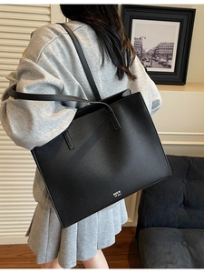 Minimalist black lychee leather tote bag with large capacity for women on model