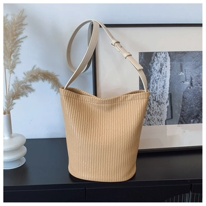 Detail der Stroh-Beuteltasche mit Webstruktur und verstellbarem cremefarbenem Lederriemen