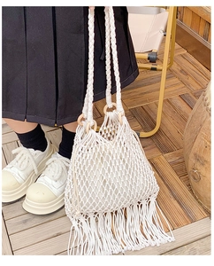 Détail du sac macramé blanc avec des franges et des poignées en anneaux de bois