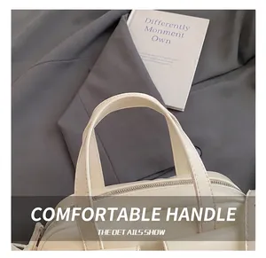 Détail de la poignée en similicuir de haute qualité avec coutures précises sur sac blanc