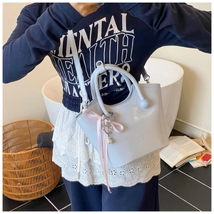 Détail du sac seau en cuir PU bleu clair avec breloque cœur perlé et ruban rose
