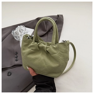 Detailed close-up of light green ruched leather bucket bag with silver metal hardware