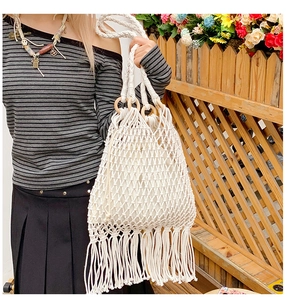 Détail du sac en filet tissé à la main avec poignée en bois, franges et doublure