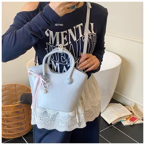 Detail of light blue tote bag with pink ribbon bow and heart pearl charm accessory