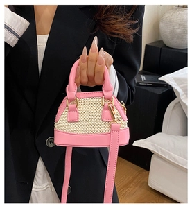Detail der Muscheltasche aus rosa Leder und Strohgeflecht mit goldenen Beschlägen