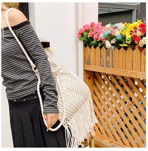 Gros plan détaillé du sac à bandoulière en crochet blanc avec de longues franges tressées