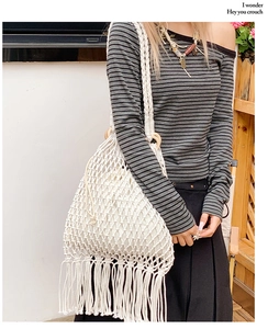 Détail du sac crochet blanc avec poignées rondes en bois et de longues franges à glands