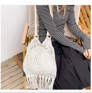 Détail du sac en macramé bohème avec poignées en bois et finitions de franges élégantes