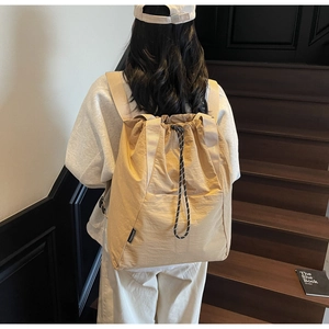 Khaki nylon drawstring backpack featuring a side brand label on lightweight material