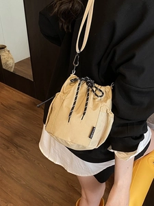 Chic khaki drawstring bucket bag with mesh side pocket and casual crossbody style