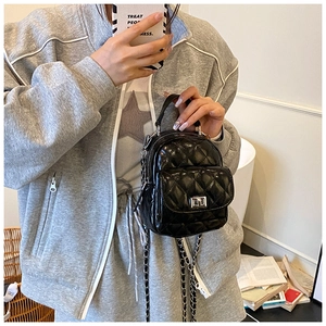 Dettaglio mini zaino nero trapuntato con catena in metallo e chiusura a girello elegante