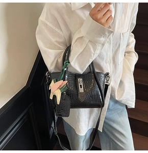 Close-up of black crocodile leather handbag with silver lock and pegasus charm