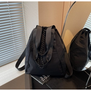 Detail of black waterproof nylon drawstring backpack with wide straps and large front pocket