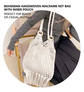 Détail d'un sac en maille tissée avec poignées en bois et finitions à franges bohèmes