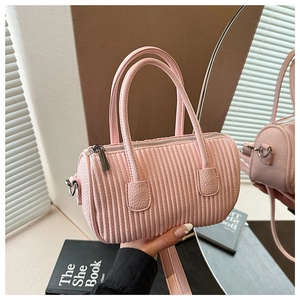 Macro detail of pink pleated cylinder bag showing leather texture and silver metal rings