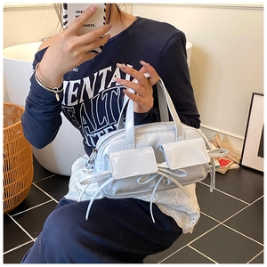 Détail du sac en cuir verni bleu clair avec poches symétriques et nœuds décoratifs
