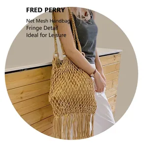 Détail d'un sac en maille tissée beige avec de longues franges pour un style d'été