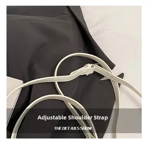 Detail of adjustable white PU leather shoulder strap with silver buckle for handbag
