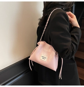 Detail of pink cloud-shaped bucket bag with leather chain strap and drawstring closure