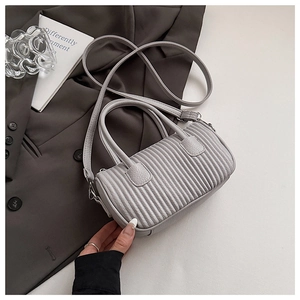 Detail of light grey pleated pillow bag with wavy texture and adjustable shoulder strap