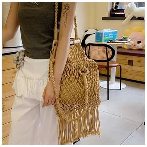 Détail du sac à bandoulière tissé avec longues franges et anneaux en bois sur la sangle