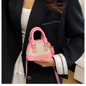 Detailansicht einer Mini-Strohtasche mit rosa Lederbesatz und goldenen Beschlägen
