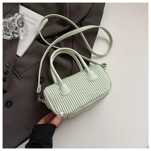 Detail of mint green pleated handbag with vertical texture and adjustable shoulder strap